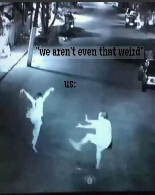 This may contain two people are dancing on the street in front of a sign that says we arent even that weird us