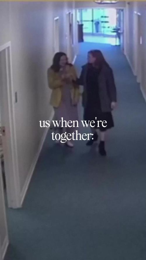 two women walking down a long hallway with the caption us when were together